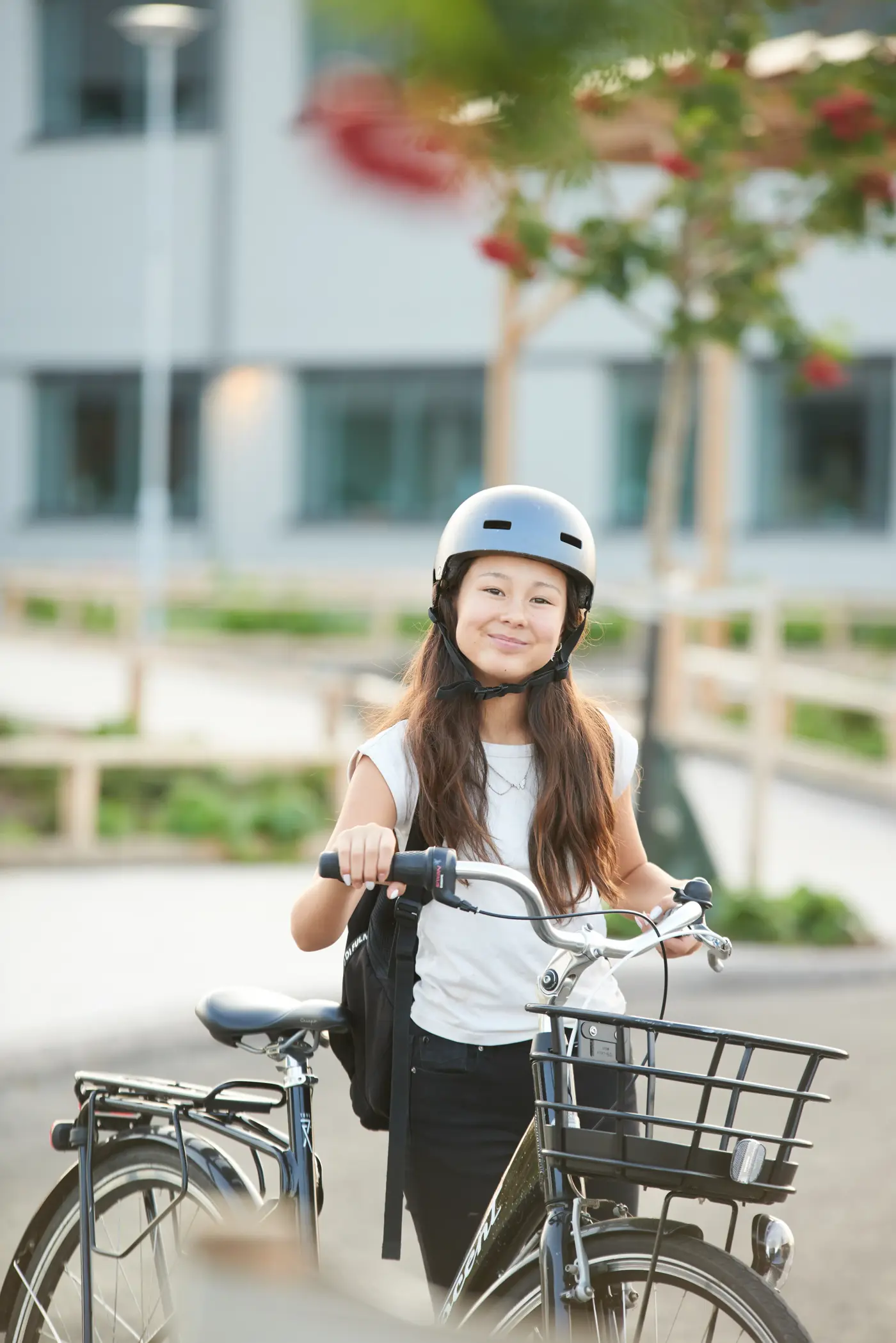 Skolungdom som står brevid sin cykel och ler.