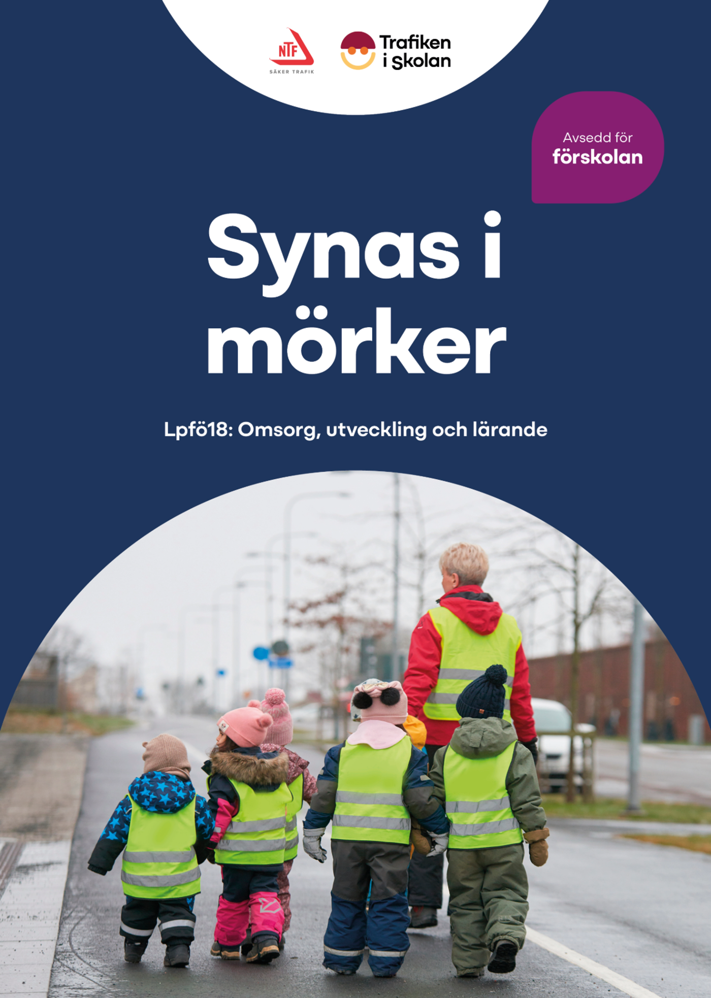 En förskolegrupp med reflexvästar promenerar på en gångväg.